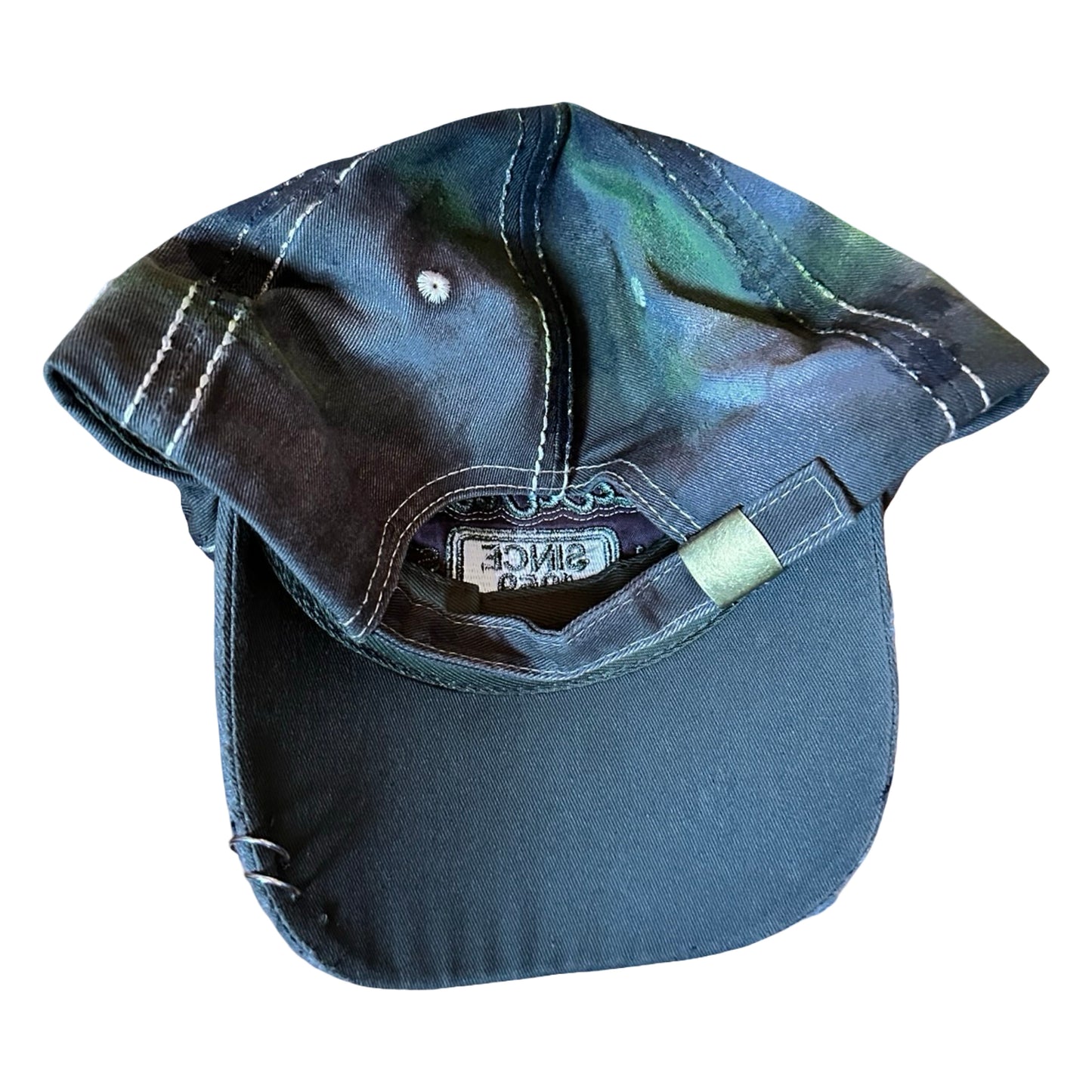Back image of “Green and brown distressed ASTROBOI* Hawaii hat with rhinestones, metallic paint, and sterling-steel piercings, customized in NYC.”