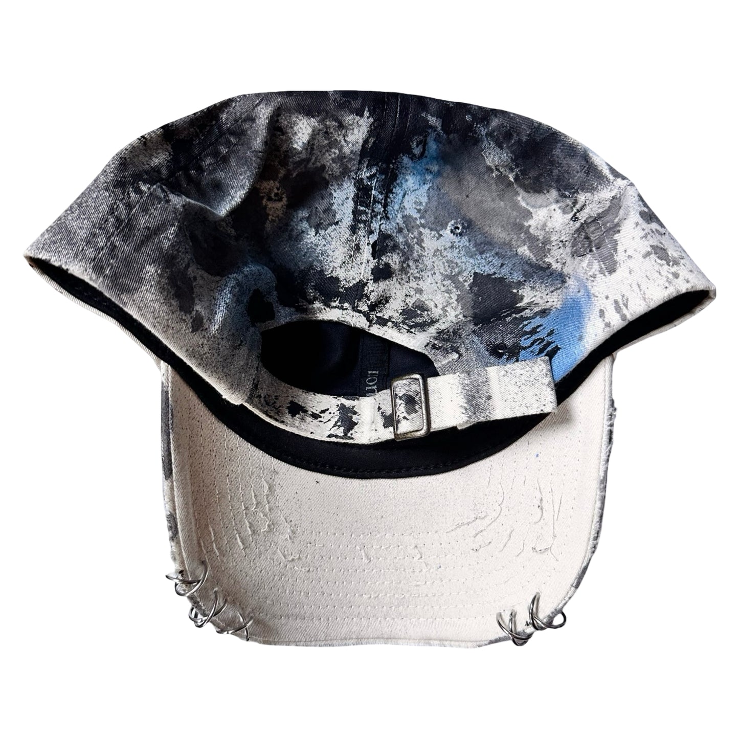 Flat Back of Black Vuori baseball hat customized by ASTROBOI* with blue and black painted details, stainless steel piercings, and an embroidered V logo.