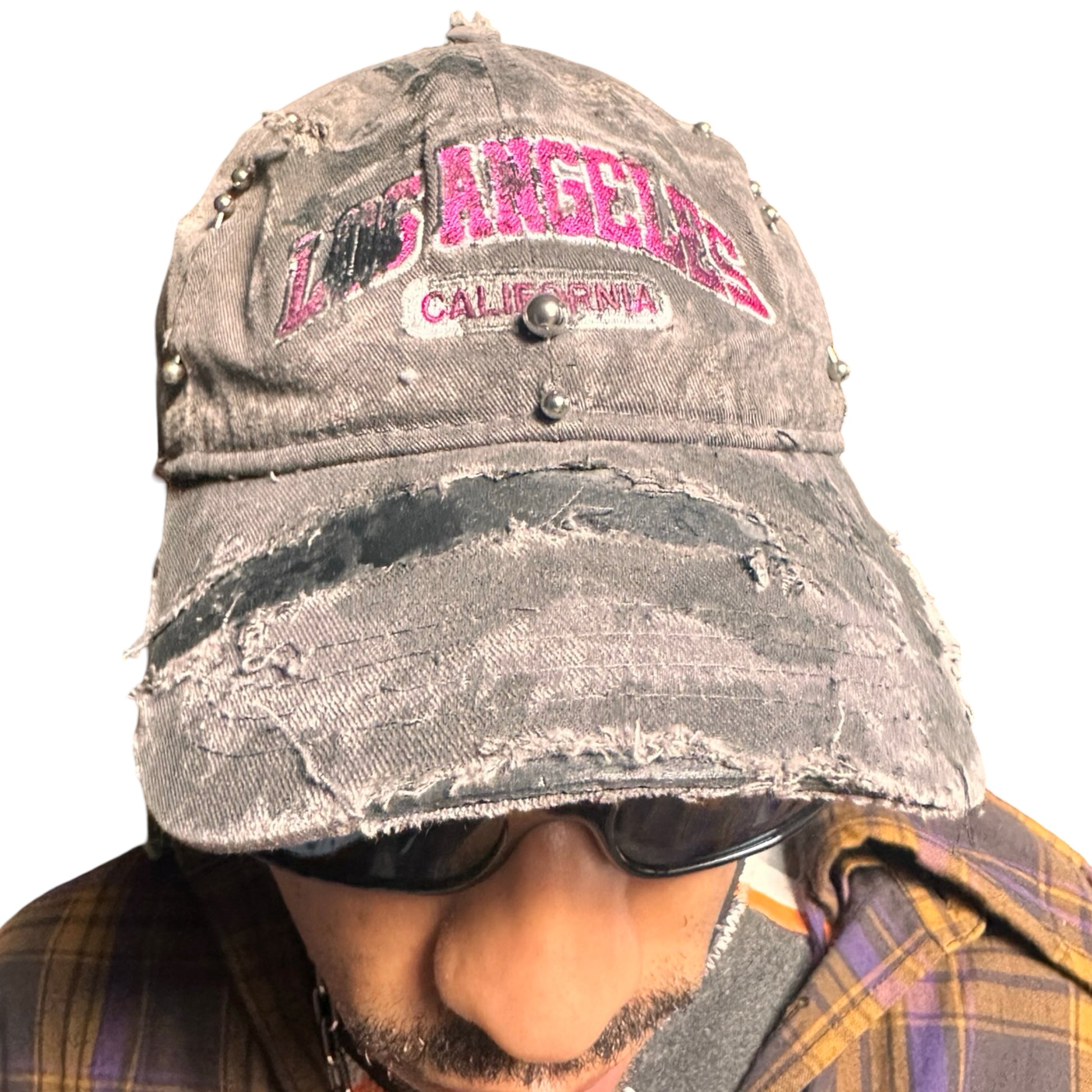 Front of Grey and pink distressed half-visor hat with ‘Los Angeles’ embroidery, black paint, and stainless steel piercings, customized by ASTROBOI*.