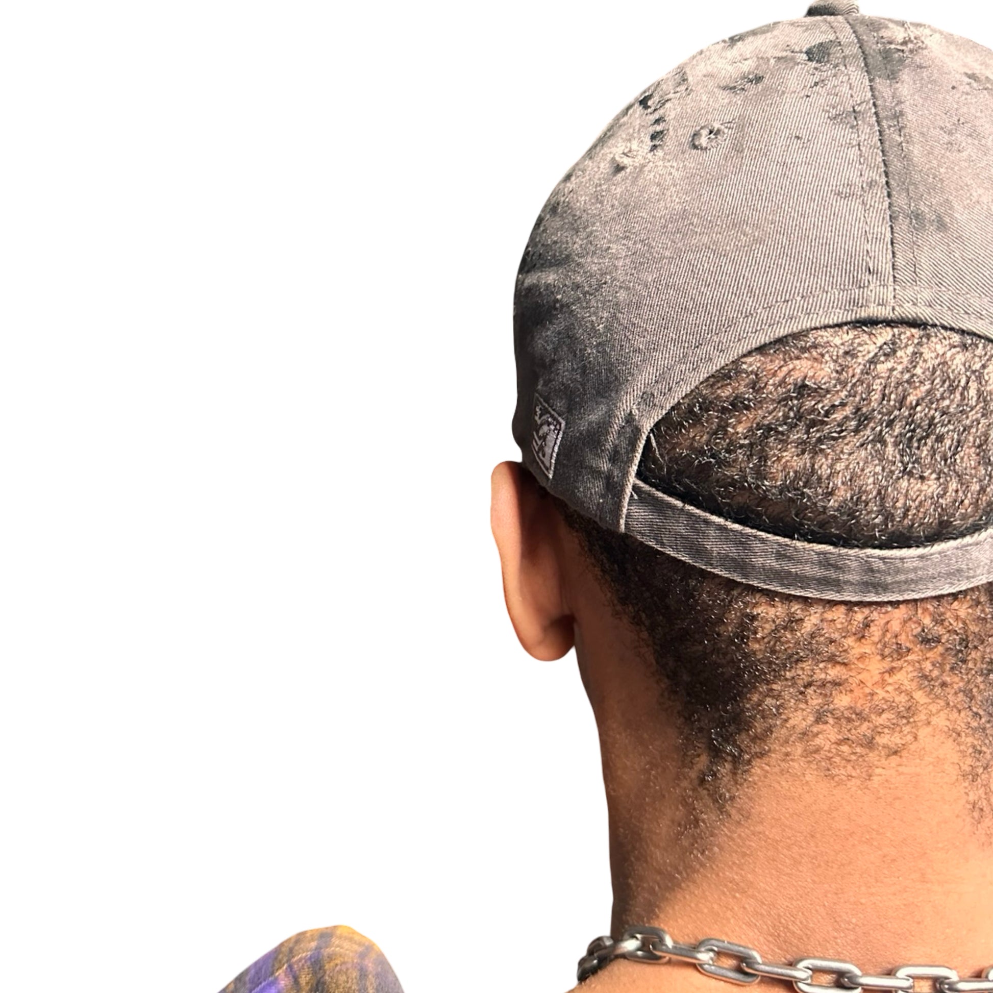 Back side of Grey and pink distressed half-visor hat with ‘Los Angeles’ embroidery, black paint, and stainless steel piercings, customized by ASTROBOI*.