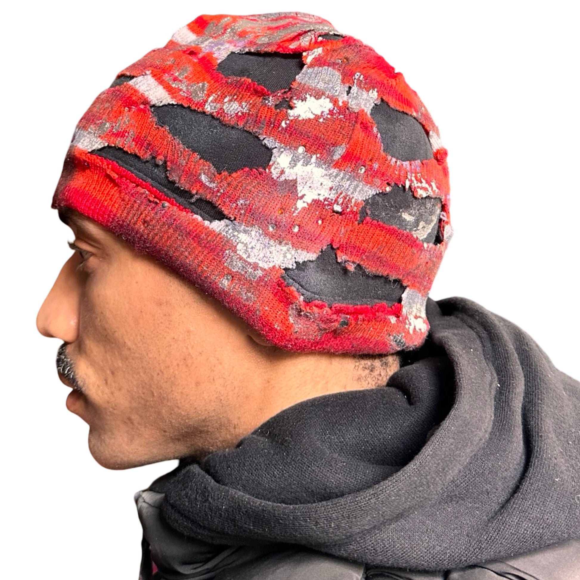 Left of ASTROBOI* orange and red striped beanie with cutouts, black fleece lining, rhinestones, and metallic paint. Distressed Y2K custom hat handmade in NYC.
