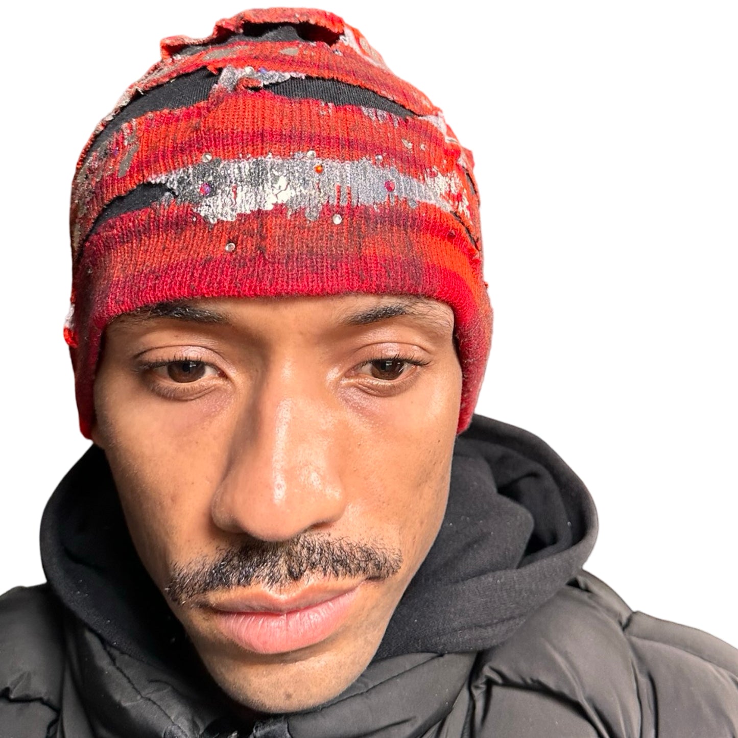 Front of ASTROBOI* orange and red striped beanie with cutouts, black fleece lining, rhinestones, and metallic paint. Distressed Y2K custom hat handmade in NYC.