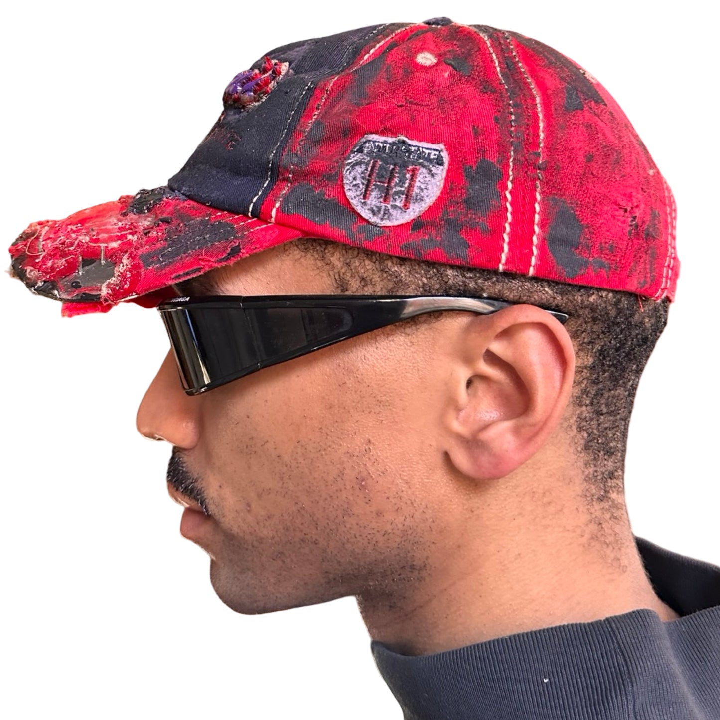 Left of Blue and red ASTROBOI* hat featuring a purple resin-coated Hawaii graphic, deconstructed visor with clear resin, and black painted accents.