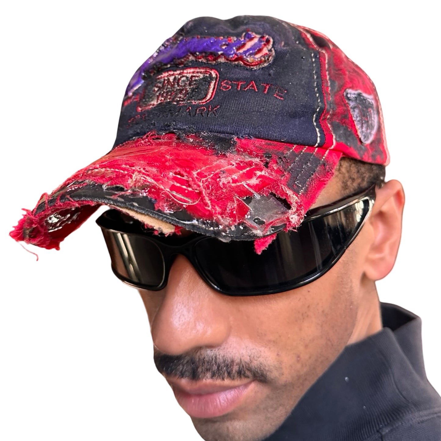 Front left of Blue and red ASTROBOI* hat featuring a purple resin-coated Hawaii graphic, deconstructed visor with clear resin, and black painted accents.