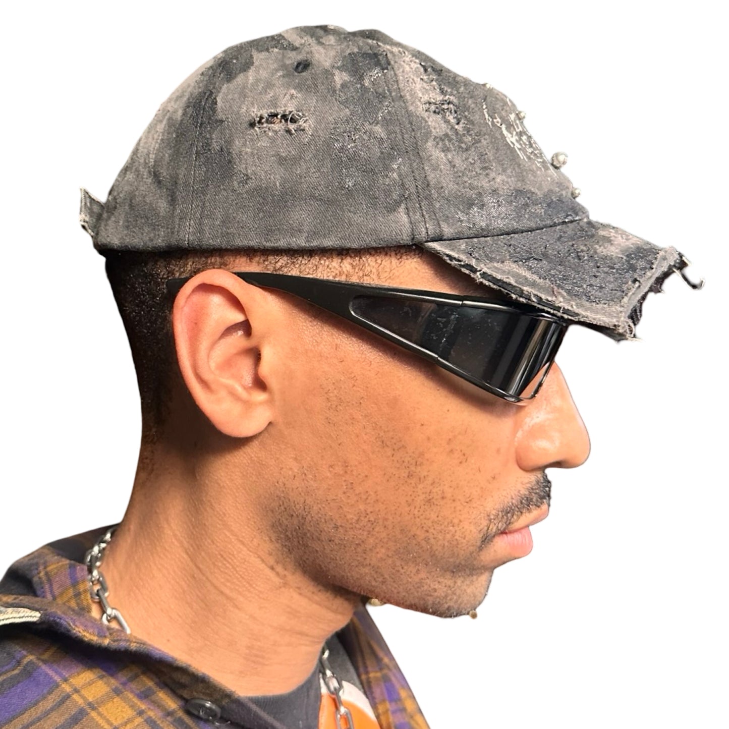 Right side of Black distressed half-visor hat with barbed-wire logo, adjustable strap, black paint details, and stainless steel piercings along the brim.