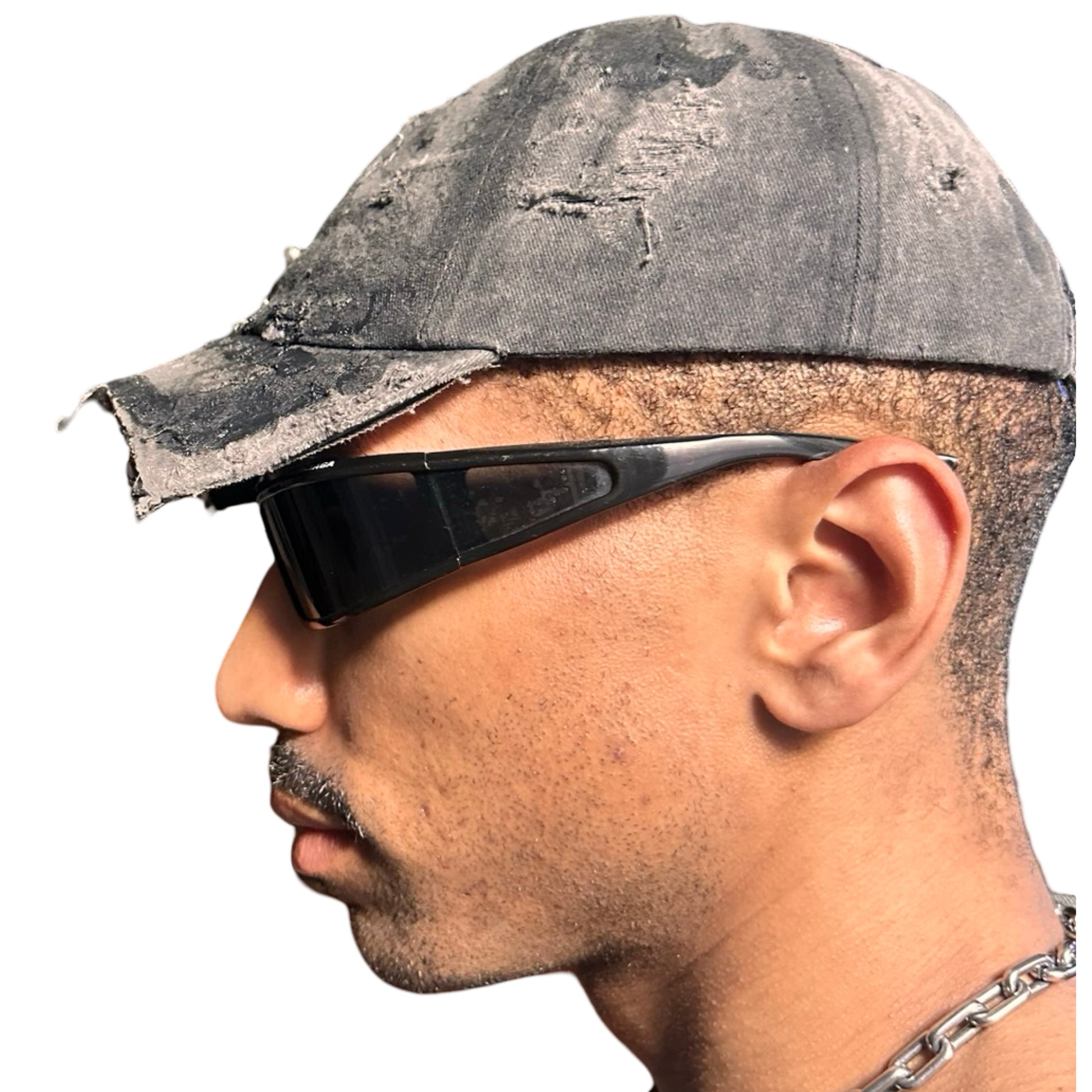 Left side of Black distressed half-visor hat with barbed-wire logo, adjustable strap, black paint details, and stainless steel piercings along the brim.