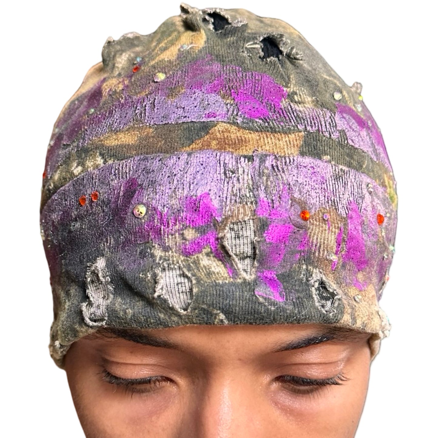 Front of ASTROBOI* brown RealTree grunge beanie with ripped details, lavender and magenta paint, and colorful rhinestones, handmade in NYC.
