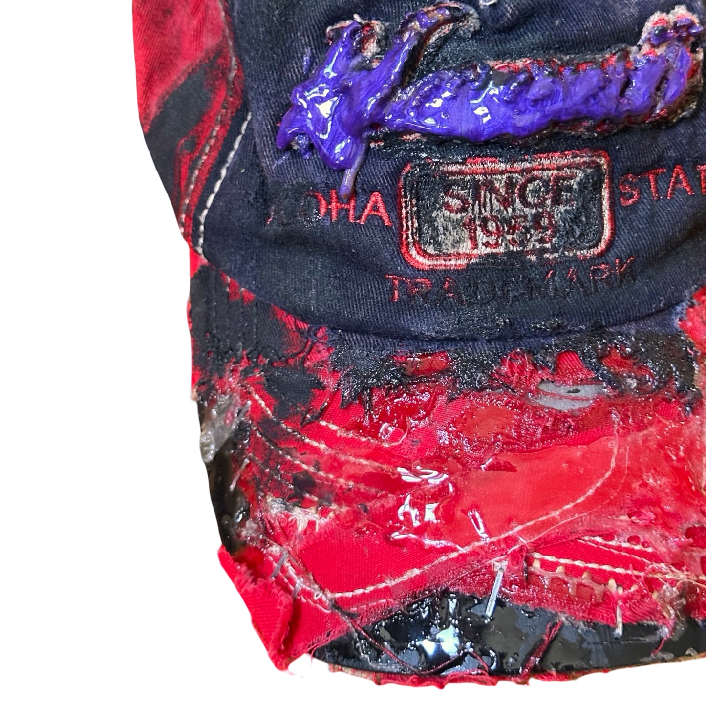 Flat lay front close up of Blue and red ASTROBOI* hat featuring a purple resin-coated Hawaii graphic, deconstructed visor with clear resin, and black painted accents.