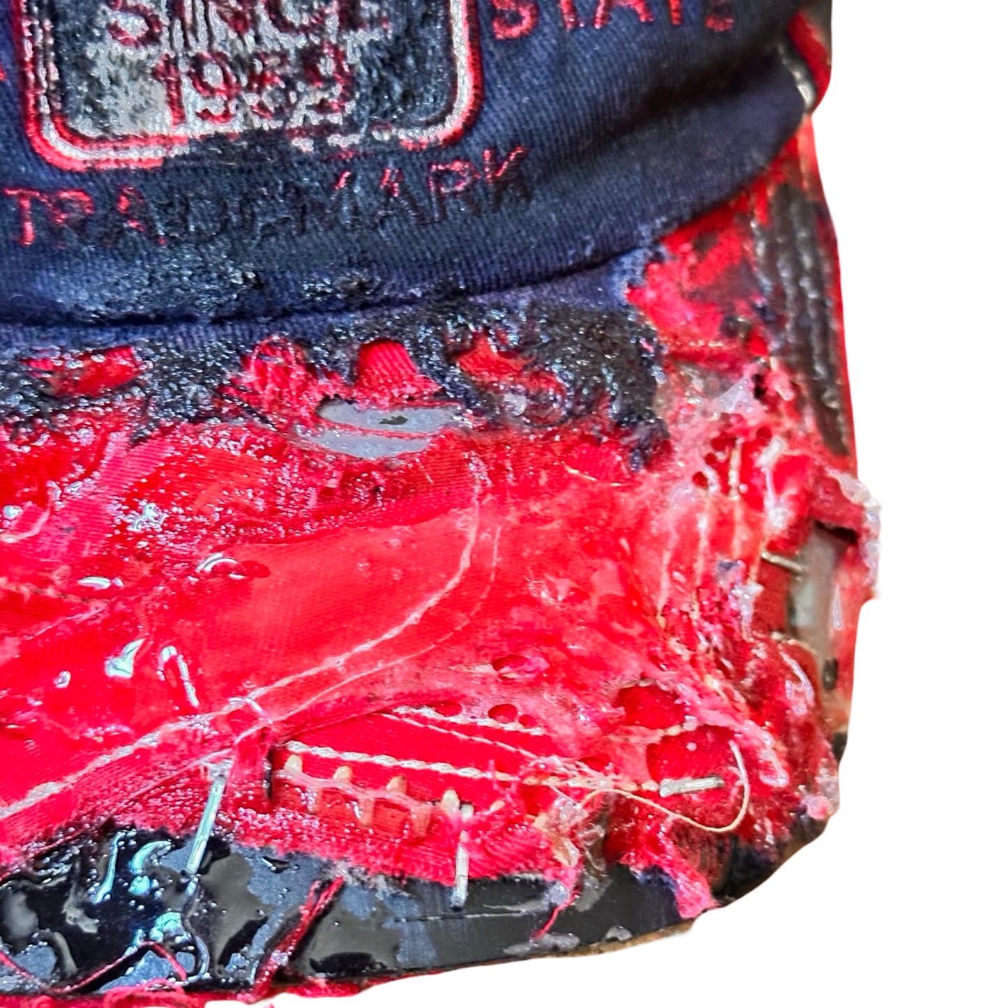 Flat lay visor detail of Blue and red ASTROBOI* hat featuring a purple resin-coated Hawaii graphic, deconstructed visor with clear resin, and black painted accents.