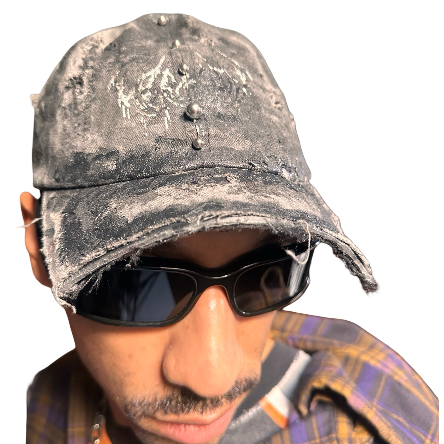 Front right side of Black distressed half-visor hat with barbed-wire logo, adjustable strap, black paint details, and stainless steel piercings along the brim.